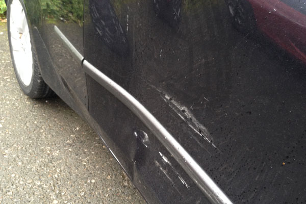 large scratch down the side of a vehicle before paint