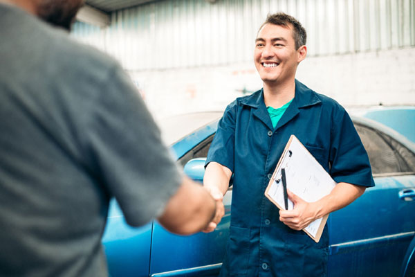 Man greeting customer with clip board for estimation of repair